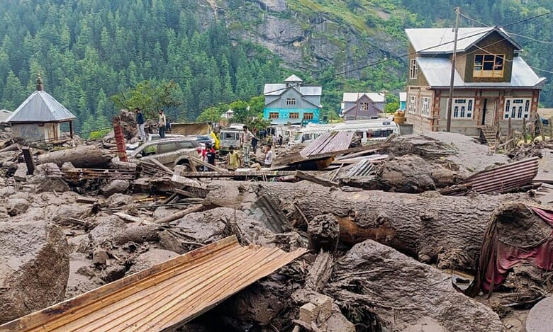 People move through the debris after a massive cloudburst at Chasoti village in Jammu and Kashmir's Kishtwar district on Thursday. (PTI Photo)
