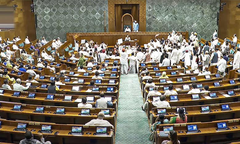 Opposition members protest in the well of the Lok Sabha during the Monsoon session of Parliament in New Delhi on Wednesday. (Sansad TV via PTI Photo)