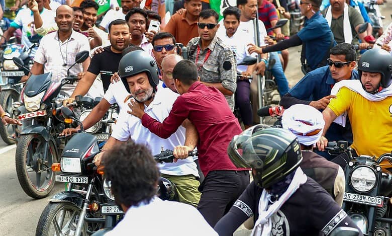 Leader of Opposition in the Lok Sabha Rahul Gandhi being hugged by a supporter as the former rides a motorcycle during the Voter Adhikar Yatra in Bihar. (AICC via PTI Photo)