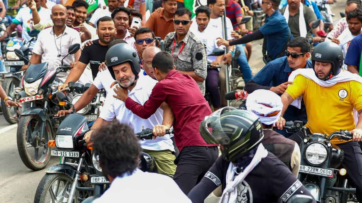 Leader of Opposition in the Lok Sabha Rahul Gandhi being hugged by a supporter as the former rides a motorcycle during the Voter Adhikar Yatra in Bihar. (AICC via PTI Photo)