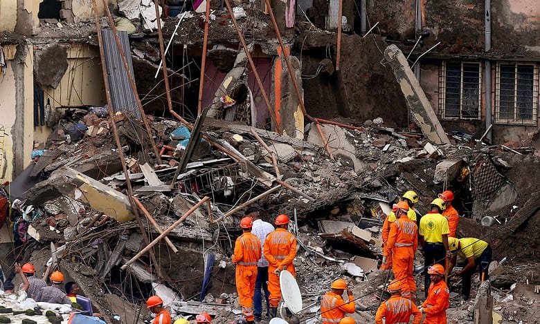 Rescue operation underway after a four-storey unauthorised building collapsed onto adjacent vacant chawl, at Virar on Thursday. (PTI Photo)
