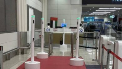 AI-powered passenger corridor at Dubai Airport with multiple biometric scanning stations on a red carpet.