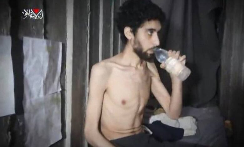 Emaciated Israeli hostage seen drinking water inside a dimly lit concrete tunnel in Gaza, appearing weak and malnourished.