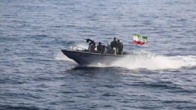 Iranian navy speedboat with soldiers and mounted gun sails during military exercise in open waters.
