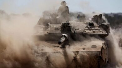 Israeli tank advancing through dust during Gaza ground offensive.