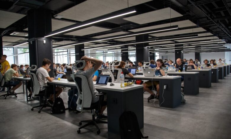 Representative image of a modern open-plan office with employees working on laptops.