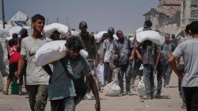 The image of Palestinians carrying sacks of flour from a humanitarian aid convoy in Gaza City, July 27, 2025.