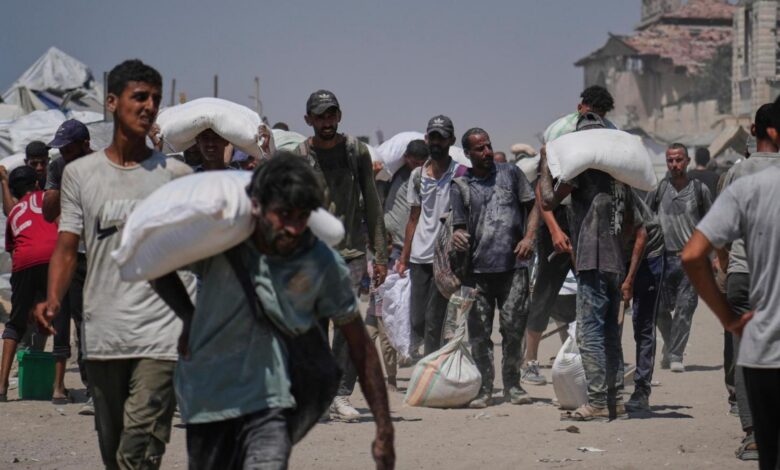 The image of Palestinians carrying sacks of flour from a humanitarian aid convoy in Gaza City, July 27, 2025.
