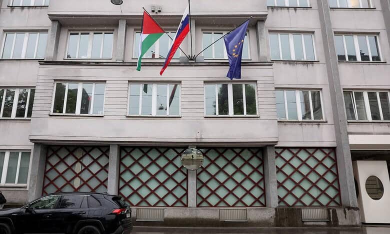 The Palestinian, Slovenian, and European Union flags are seen flying outside a government building in Ljubljana, Slovenia.