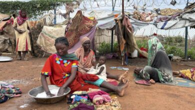 Women wash clothes at Renk transit centre sheltering Sudan war refugees, South Sudan, August 2025.