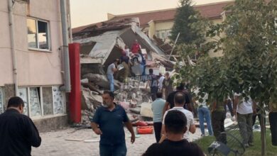 People gather near a collapsed building in Balıkesir, Turkey, after a 6.1-magnitude earthquake.