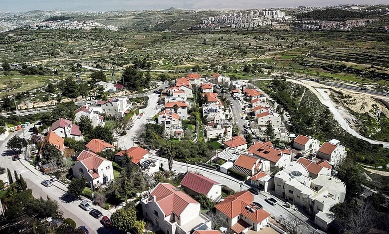Aerial drone view of the West Bank landscape with Israeli settlements.