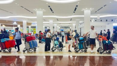 Passengers with luggage trolleys at Dubai International Airport terminal