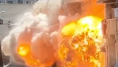 Explosion with large flames and thick smoke engulfing a building.