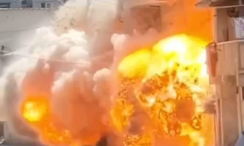 Explosion with large flames and thick smoke engulfing a building.