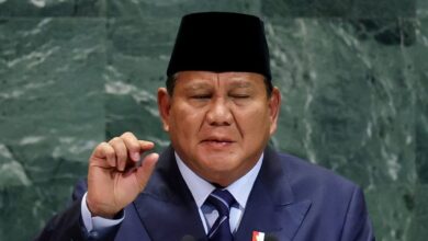 Indonesian President Prabowo Subianto, wearing a dark suit, striped tie, and traditional black peci hat, addresses the United Nations General Assembly.