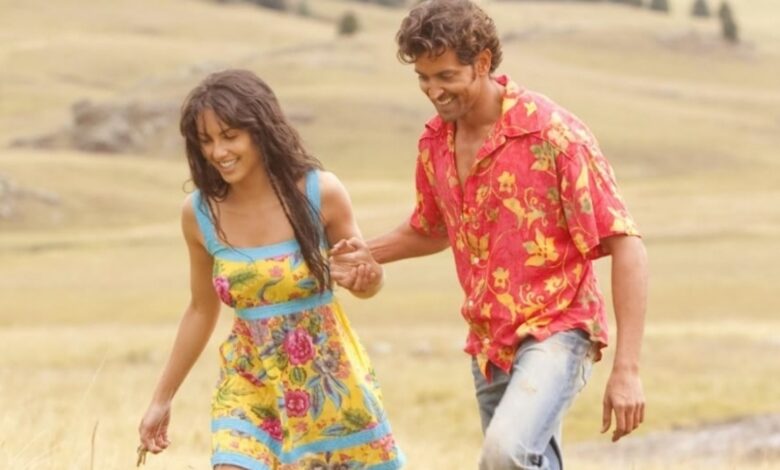A couple joyfully walks hand-in-hand through a golden field, smiling and enjoying the sunny day.