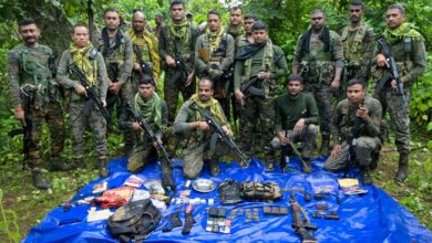 Security personnel with the arms, ammunition and other items recovered from Maoists during a gunfight