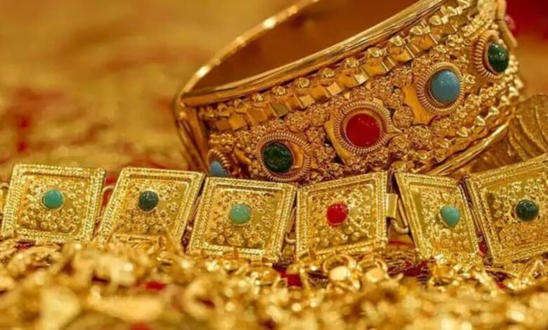 Exquisite gold jewelry with colored gemstones, traditional and luxurious, showcased on a rich surface.