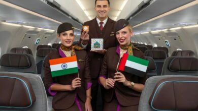 Etihad Airways cabin crew pose inside an aircraft holding Indian and UAE flags, celebrating the new Abu Dhabi–Kolkata A321LR service.