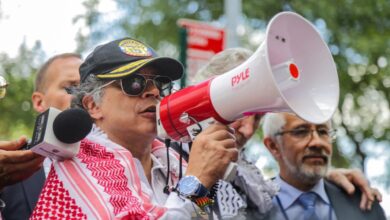 Colombian President Gustavo Petro speaks through a megaphone at a pro-Palestinian demonstration outside the United Nations headquarters, wearing a black cap and red-and-white keffiyeh.