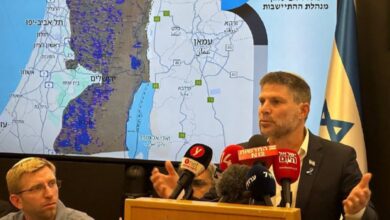 Bezalel Smotrich speaking at a press conference with a map of the West Bank behind him.