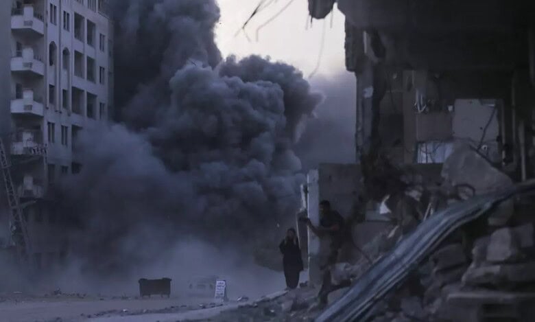 Palestinians take cover amid rubble as thick smoke rises from a building hit by an Israeli airstrike in Gaza City, September 7, 2025.