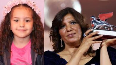 Kaouther Ben Hania with award next to photo of Hind Rajab.