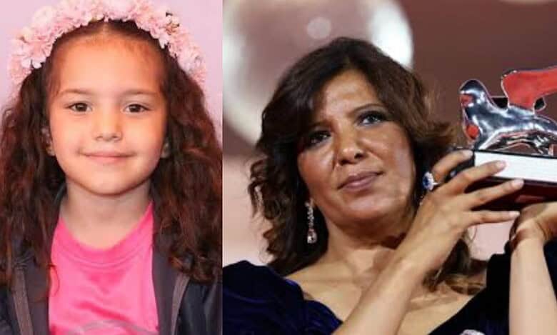 Kaouther Ben Hania with award next to photo of Hind Rajab.