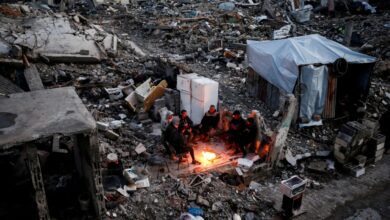 Palestinians sit around a fire amid rubble in Jabalia refugee camp, northern Gaza.
