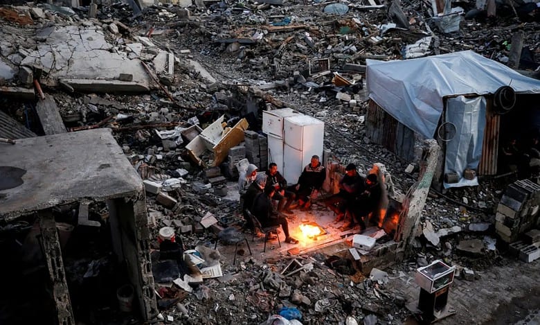 Palestinians sit around a fire amid rubble in Jabalia refugee camp, northern Gaza.