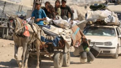 A group of Palestinians, including children, flee Gaza City on a horse-drawn cart loaded with belongings, alongside a car, amid an evacuation order.