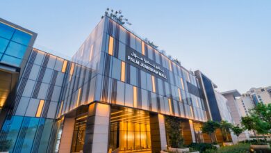 Aerial view of Palm Jumeirah Mall at night, with illuminated retail and dining areas surrounded by high-rise buildings.