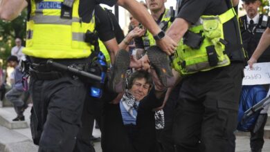 Police officers carry away a protester during a demonstration in London.