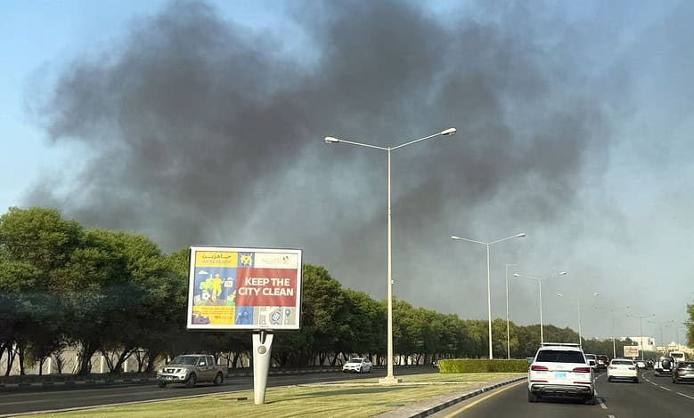 Black smoke rises above trees and a busy road in Doha following reported explosions.