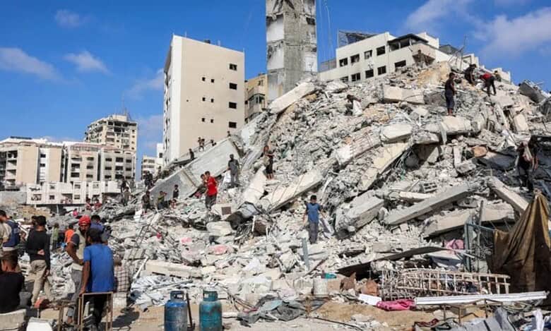 People search through rubble after the destruction of the al-Sousi Tower in Gaza City.