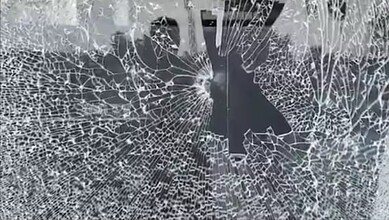 The image shows the glass of Pavan Nexa showroom in Nalgonda town being vandalised by a BJP worker during BC bandh on Saturday, October 18, 2025.