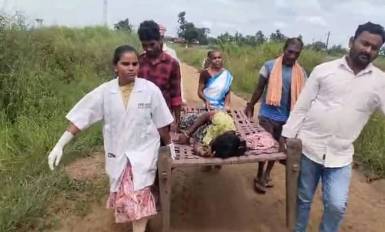 108 ambulance team carry a heavily pregnant Gotti Koya woman on a cot