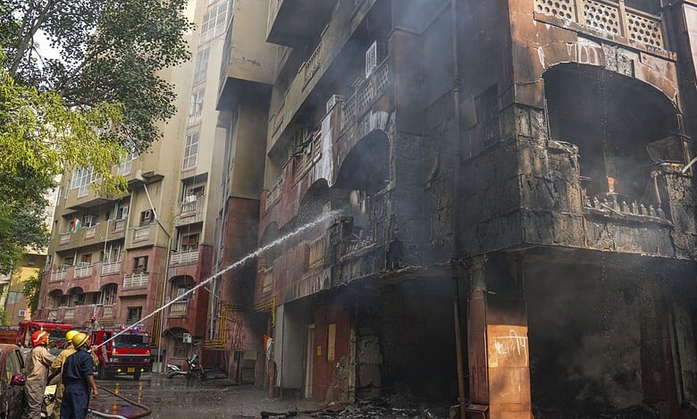 Firefighters try to douse a fire that broke out at Brahmaputra Apartments, in New Delhi on Saturday. The apartment complex houses residences of several Lok Sabha and Rajya Sabha MPs. (PTI Photo/Karma Bhutia)