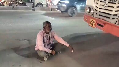 Man sits in front of RTC bus in Hyderabad