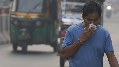 A commuter covers his face while making his way amid low visibility as air quality deteriorates across Delhi-NCR, in New Delhi, Tuesday, Oct. 21, 2025. (PTI Photo/Shahbaz Khan)