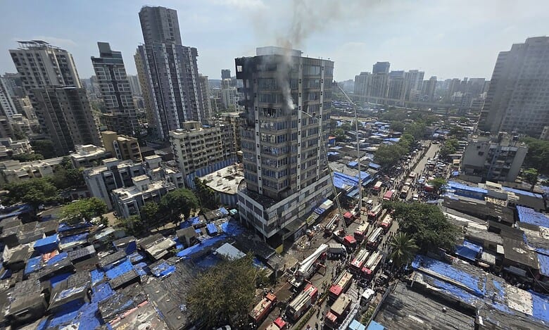 Smoke billows while firemen douse a fire breaking out at 13-storey commercial building JNS Business Center at Jogeshwari area in Mumbai on Thursday (PTI Photo)