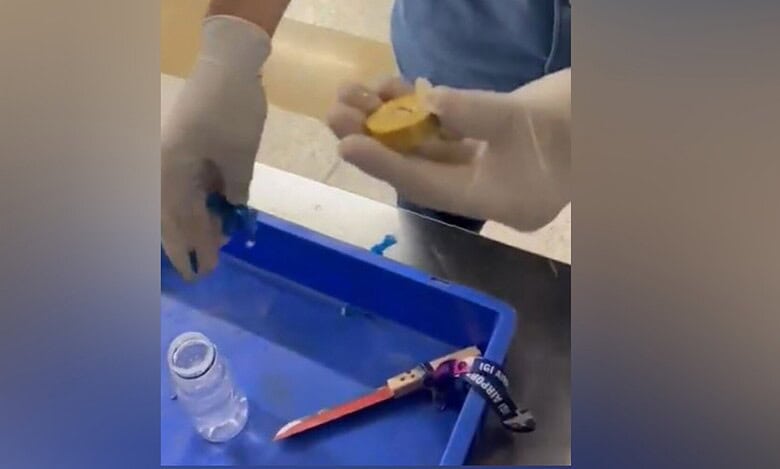 Customs officer holds a gold piece hidden inside a beverage bottle cap seized from a Dubai passenger at Delhi airport.