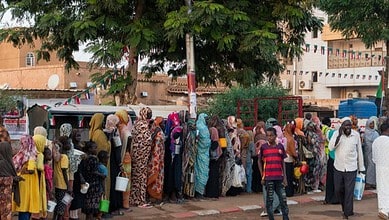 Recently displaced families from El-Fasher queue for food aid in Omdurman, Sudan.