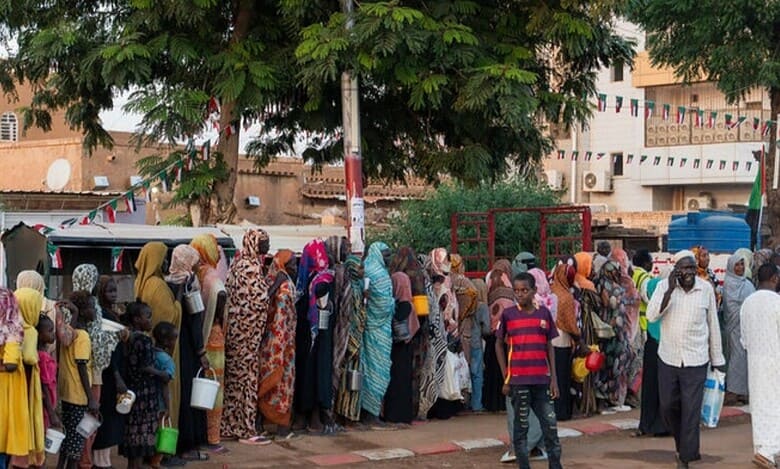 Recently displaced families from El-Fasher queue for food aid in Omdurman, Sudan.