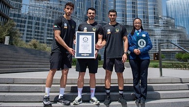 Dubai Civil Defence firefighters pose with Guinness World Record certificate in front of the Burj Khalifa.