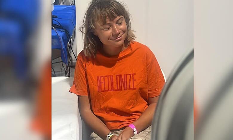 Greta Thunberg sits wearing an orange T-shirt with “Decolonize” printed on it after Israel intercepted the Global Sumud Flotilla boats.