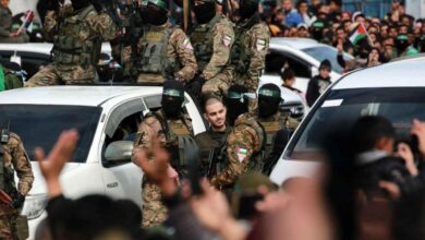 Hamas militants escort a captive during a public rally in Gaza.