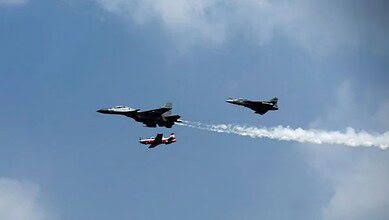 Indian Air Force fighter jets performing in formation during a flight demonstration.