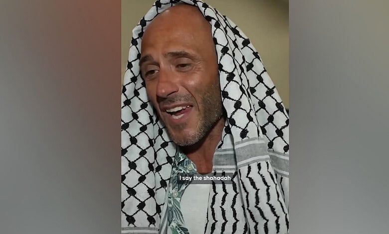 Italian activist wearing a black-and-white Palestinian keffiyeh speaks after embracing Islam.